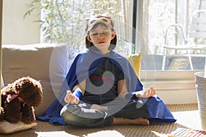 Tired superhero lockdown child relaxing with soothing yoga to outbreak