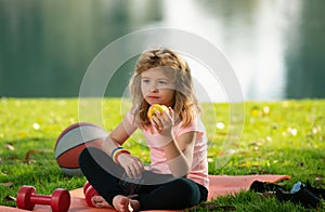 Tired teen sport boy eating apple after training in summer park. Fitness and healthy lifestyle concept. Concept of