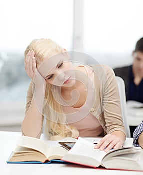 Tired teenage student with tablet pc and books