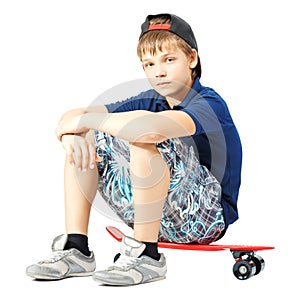 Tired teenager sitting on a skateboard