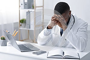 Tired therapist sitting in his office in front of laptop