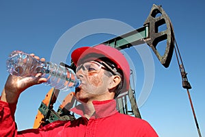 Tired and Thirsty Oil Worker at Oil Field In Desert