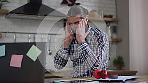 Tired unwell Middle Eastern man rubbing temples having migraine symptoms. Portrait of overburdened businessman with