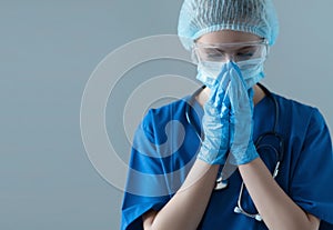 Tired, upset and depressed medical worker in protection suit. Nurse, surgeon, doctor or paramedic in blue uniform