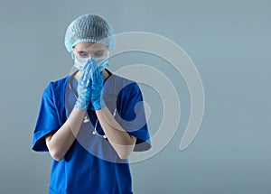 Tired, upset and depressed medical worker in protection suit. Nurse, surgeon, doctor or paramedic in blue uniform