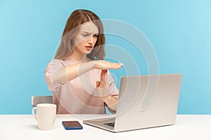 Tired upset woman employee showing time out gesture and looking at laptop screen, talking on video call