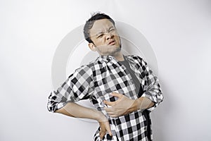 Tired upset young man suffering from back pain, muscle spasm at workplace. Fatigue, deadline, pain and incorrect posture