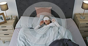 Tired, wake up and woman sleeping in bed for rest on a weekend morning at modern apartment. Top view, relaxing and young