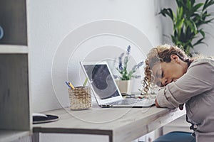 Tired woman asleep in fron tof laptop computer at home in office workstation room. Adult female people sleeping for overwork