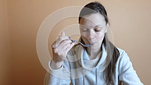 Tired woman bruenette in gray jacket eats vegetable salad after work.