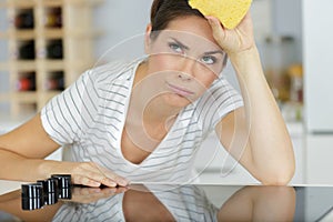 Tired woman cleaning kitchen with sponge photo