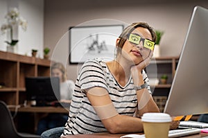 Tired woman covering eyes with post it