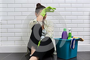 Tired woman doing house cleaning in bathroom. Fatigue, stress, cleanliness, home