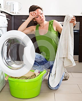 Tired woman doing laundry at home