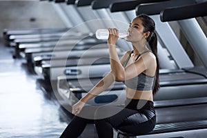 Tired woman drink water after running