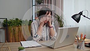 Tired woman freelancer suffering from headache migaine , closing eyes meditating at home office