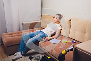 Tired woman having rest after cleaning home, lying on sofa in the living-room, copy space. Housekeeping and home