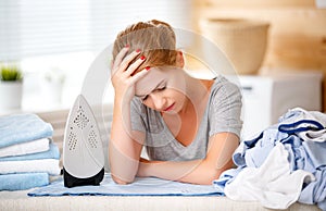 Tired woman housewife ironing clothes iron in laundry