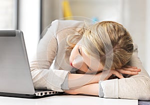 Tired woman with laptop computer photo