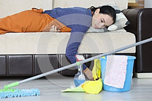 Tired woman lies on couch after cleaning apartment