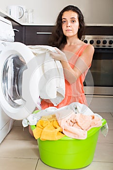 Tired woman near washing machine