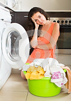 Tired woman near washing machine