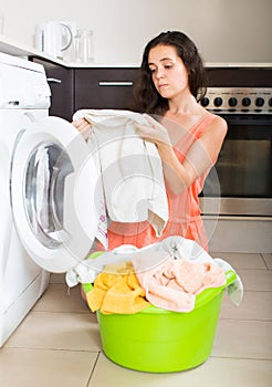 Tired woman near washing machine