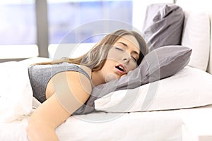 Tired woman resting on a bed at home photo