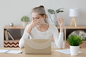 Tired woman rubbing eyes taking off glasses after computer work