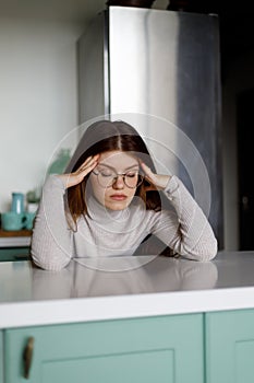 Tired woman sits with her eyes closed. Bad mood and sadness after a working day