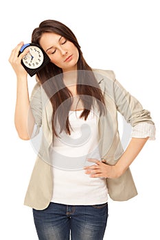 Tired woman standing with alarm-clock. Concepts of insomnia