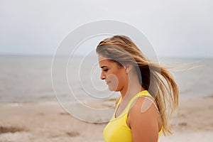 Tired woman standing on the beach