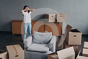 Tired woman surrounded by carton boxes feels stress of relocation. Advertising of moving company