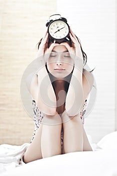 Tired woman with thealarm clock