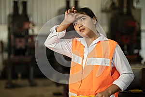 Tired woman worker Asian labor hard work in hot factory wiping away sweat