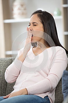 tired woman yawning and covering mouth