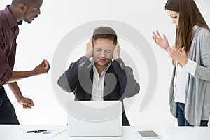 Tired from work or noise businessman closing ears with hands