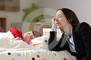 Tired worker mother sleeping beside her daughter