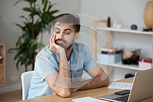 Tired worker wasting time at workplace distracted from boring job