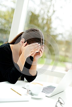 Tired worried woman resting her head in her hands