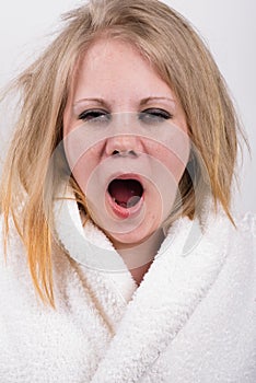 Tired yawning young woman with messy hair