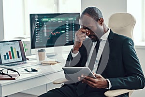 Tired young African man in formalwear