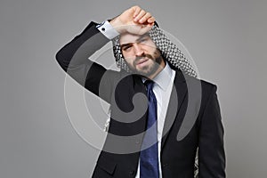 Tired young bearded arabian muslim businessman in keffiyeh kafiya ring igal agal classic black suit shirt tie isolated