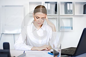 Tired young business woman with laptop computer