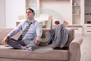 Tired young businessman coming home after working day