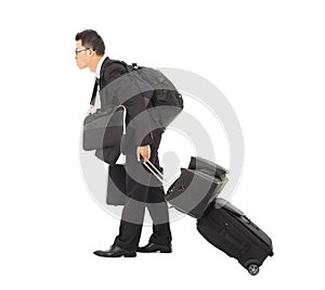 Tired young businessman pulling and belongings