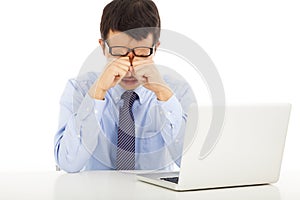 Tired young businessman rubbing his eyes photo