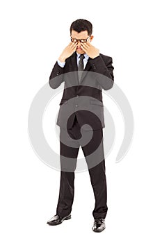Tired young businessman rubbing his eyes