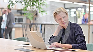 Tired Young Businesswoman with Laptop having Neck Pain in Office