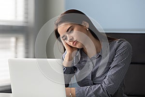 Tired young businesswoman thinking about work problem at laptop.